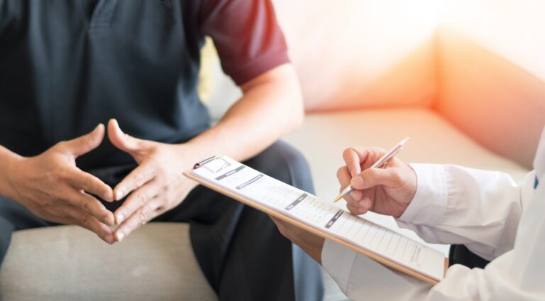 Doctor consulting a male patient with a questionnaire regarding noticeable spots.