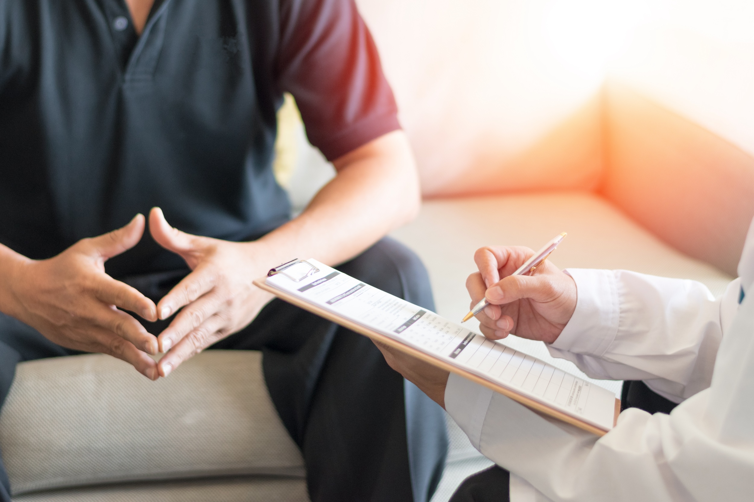 Doctor consulting a male patient with a questionnaire regarding noticeable spots.