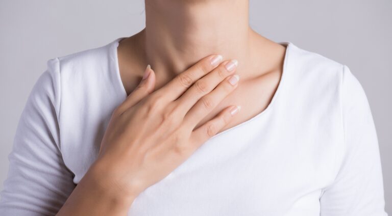 Closeup Of Young Woman with her Hand Touching Her Neck at her throat.