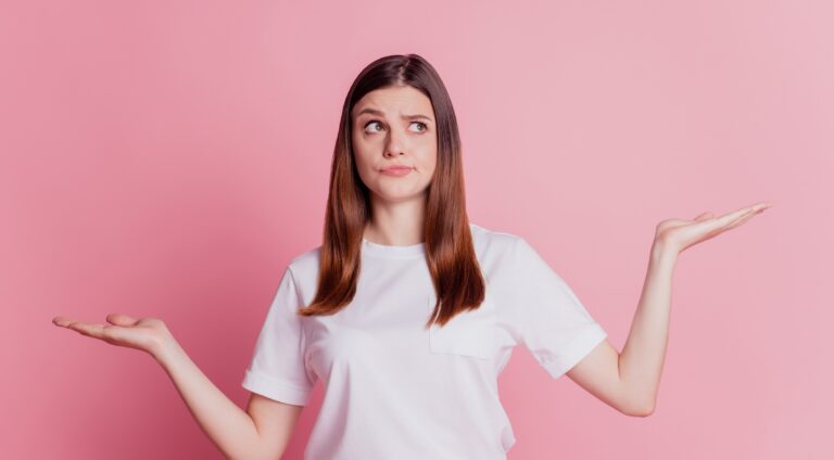 Portrait of young lady holding hands up, mentally comparing the differences between HPV and herpes with a questioning look on her face.