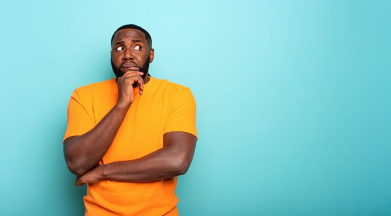 A confused and somewhat concerned black man wearing a yellow shirt, questioning whether an STD can be contracted without sex.