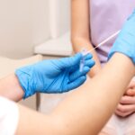 Gynecologist takes a swab for ureaplasma testing from a woman, placing the sample in the test tube.