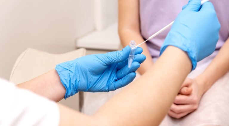 Gynecologist takes a swab for ureaplasma testing from a woman, placing the sample in the test tube.